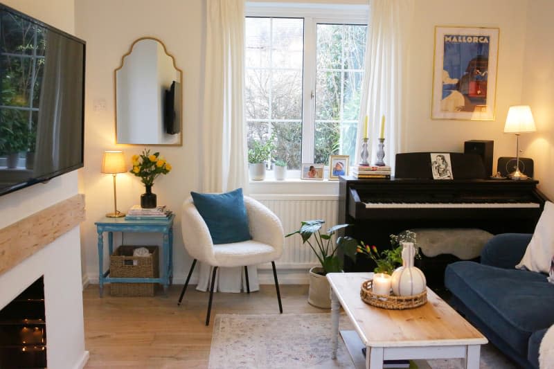 Accent chair beside upright piano in living room.