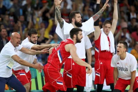 Stefan Markovic of Serbia runs on the court as bench offers encouragement. REUTERS/Damir Sagolj