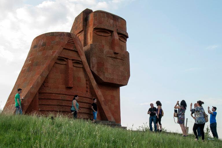 Tourists visit Grandmother and Granfather monument outside city of Stepanakert in Armenian-controlled Azerbaijani region of Nagorny Karabakh on June 26, 2013