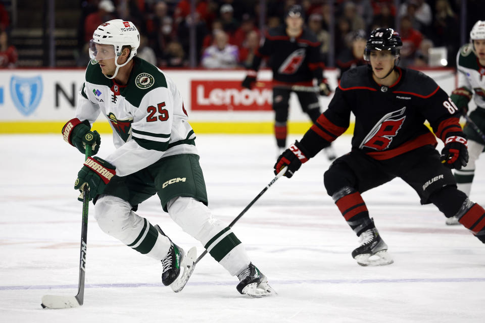 Minnesota Wild's Jonas Brodin (25) carries the puck away from Carolina Hurricanes' Teuvo Teravainen (86) during the second period of an NHL hockey game in Raleigh, N.C., Sunday, Jan. 21, 2024. (AP Photo/Karl B DeBlaker)