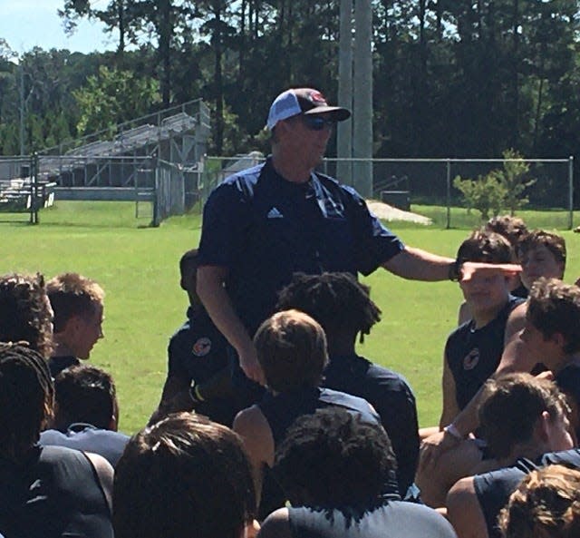 Effingham County head football coach John Ford addresses the Rebels after a summer workout.