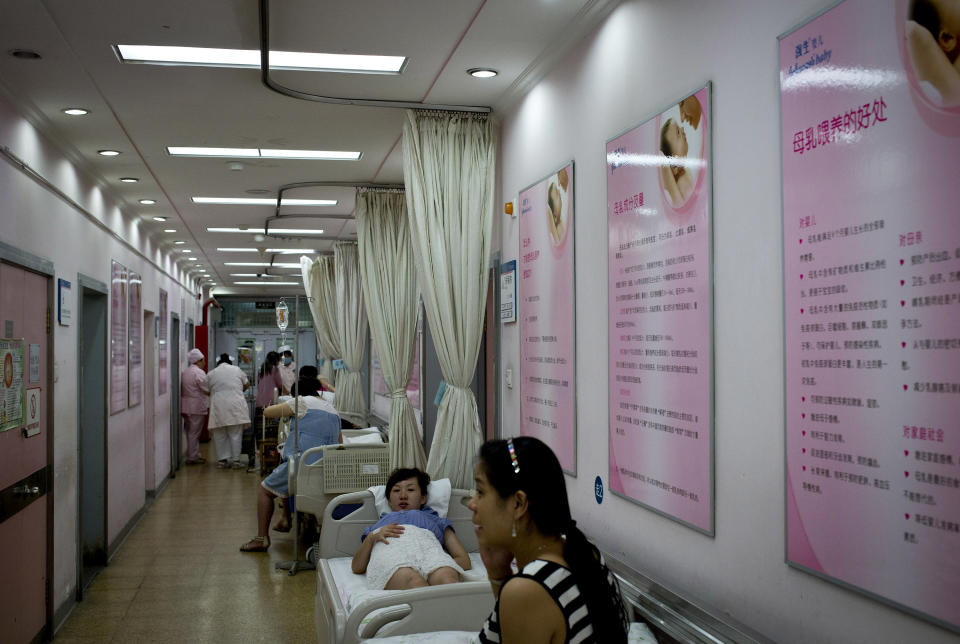 In this Wednesday, Aug. 7, 2013 photo, Chinese pregnant women rest in a corridor displaying posters on breastfeeding at Tiantan Hospital’s maternity ward in Beijing, China. China’s rates of breastfeeding are among the world’s lowest. But health workers and the government are trying to revive the tradition, and a drumbeat of safety scares over commercially produced milk is giving them new leverage. (AP Photo/Andy Wong)