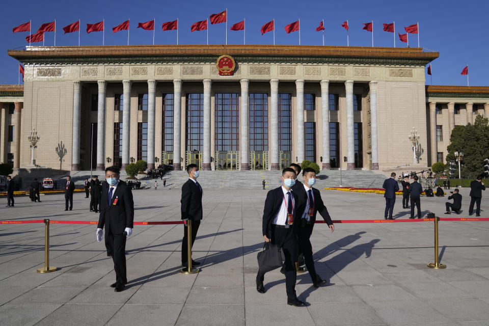 Attendees walk in front of the Great Hall of the People before the opening ceremony for the 20th National Congress of China's ruling Communist Party in Beijing, China, Sunday, Oct. 16, 2022. China on Sunday opens a twice-a-decade party conference at which leader Xi Jinping is expected to receive a third five-year term that breaks with recent precedent and establishes himself as arguably the most powerful Chinese politician since Mao Zedong. (AP Photo/Mark Schiefelbein)