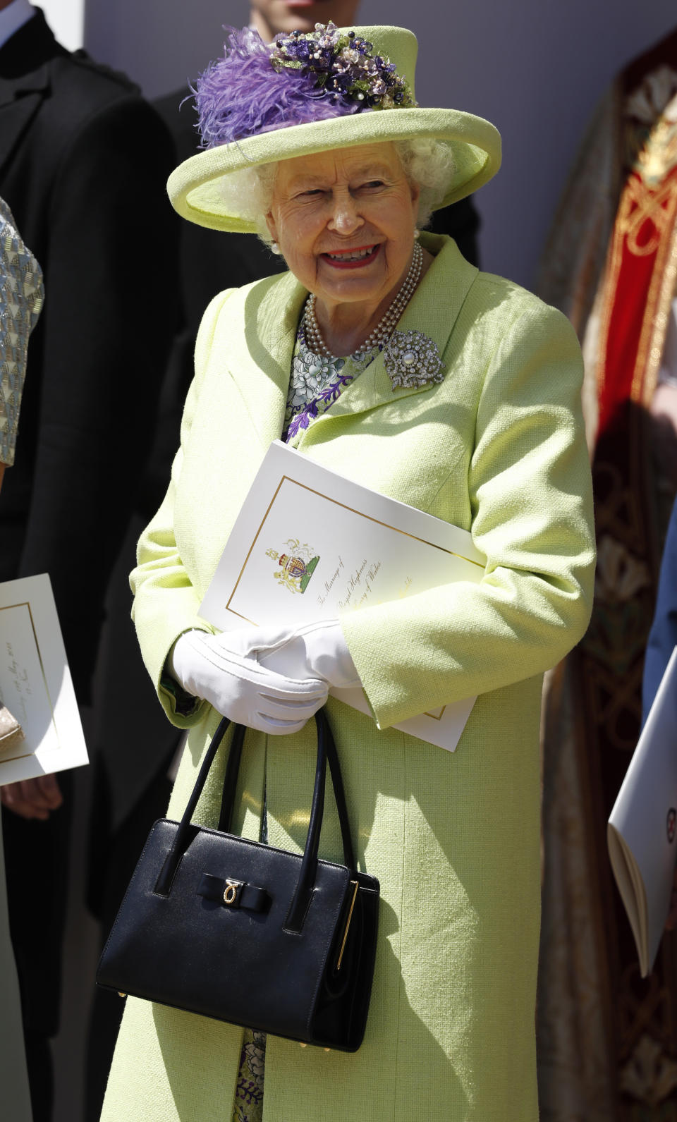 The Queen smiles as she watches Prince Harry and Meghan Markle after their Windsor Castle wedding in May 2018