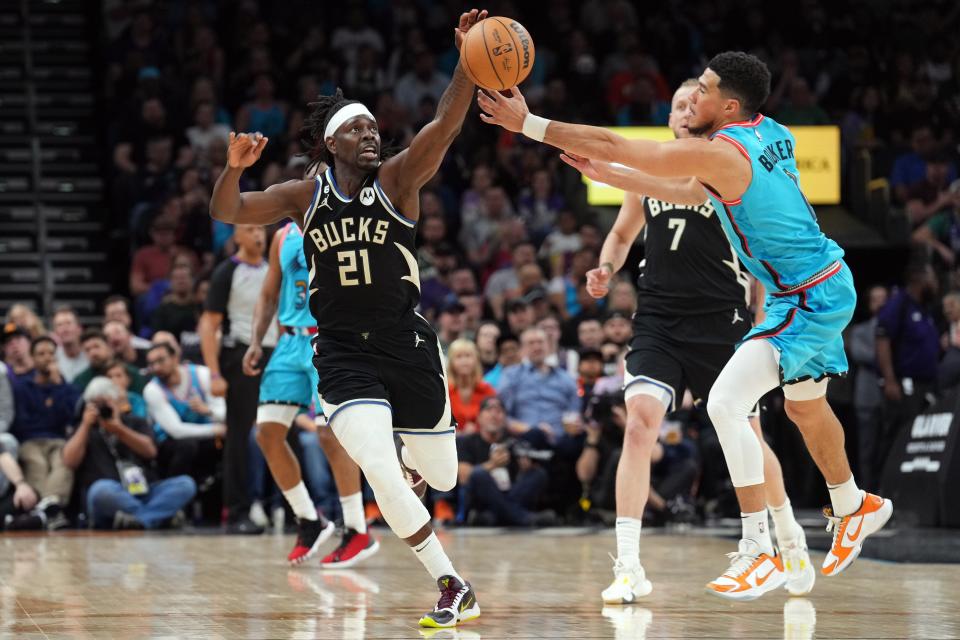 Bucks guard Jrue Holiday and Suns guard Devin Booker go after a loose ball during the second half Tuesday night.