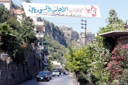 A banner is erected along a street, in the predominantly Druze village of aL-Qrayyeh, Mount Lebanon July 19, 2016. The banner reads, "Movement is banned for foreigners and Syrians from 8pm till 6am, subject to penalty". REUTERS/Mohamed Azakir