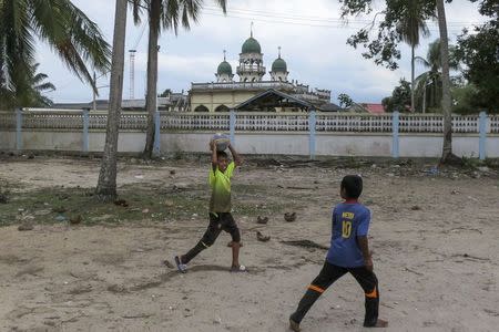Children play soccer in front of a mosque in Tanjung Pauh near Pattani June 6, 2014, one of three southernmost provinces of Thailand where government troops have fought Muslim insurgents since 2004. REUTERS/Andrew RC Marshall
