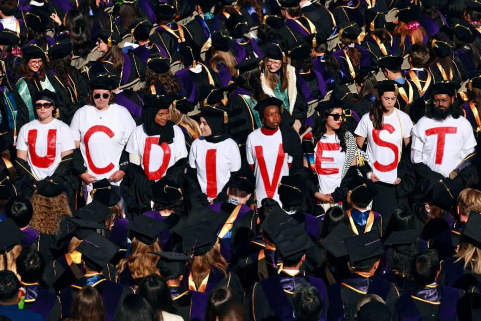 UC Berkeley Law School graduates wear T-shirts that read ‘UC DIVEST’ as a form of protest during the UC Berkeley Law School commencement at the Greek Theater in Berkeley on Friday (ONLINE_YES)