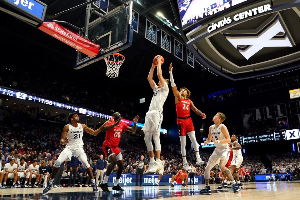 Xavier Musketeers forward Jack Nunge (24) rebounds the ball over Cincinnati Bearcats guard Jeremiah Davenport (24) in the first half of the 89th Annual Crosstown Shootout college basketball game, Saturday, Dec. 11, 2021, at Cintas Center in Cincinnati. The Xavier Musketeers won, 83-63.