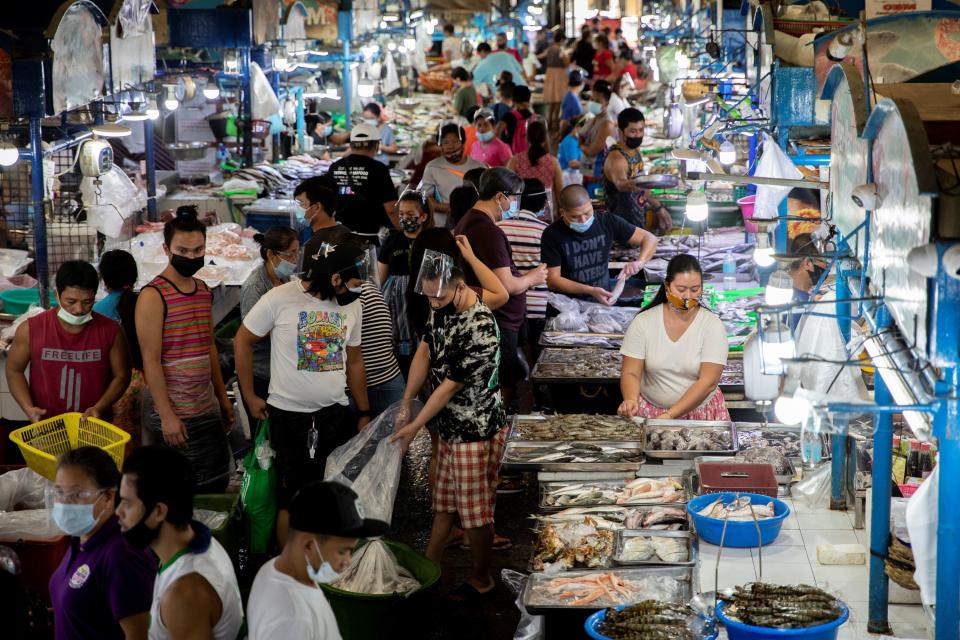 FILE PHOTO: Vendors and customers wearing face masks for protection against the coronavirus disease are seen inside a public market in Quezon City, Metro Manila, Philippines, February 5, 2021. REUTERS/Eloisa Lopez