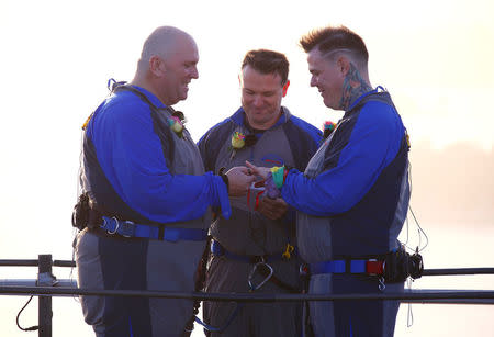 Warren Orlandi and Pauly Phillips exchange rings as they became the first same-sex couple to marry atop of the Sydney Harbour Bridge, just two days out from the 40th anniversary of the Sydney Gay and Lesbian Mardi Gras, in Australia, March 1, 2018. REUTERS/David Gray