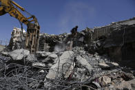 People search the rubble of a prison facility hit by a Saudi-led coalition airstrike that killed at least 87 people, in a stronghold of Houthi rebels on the border with Saudi Arabia, in the northern Saada province of Yemen, Saturday, Jan. 22, 2022. Internet access remained largely down on Sunday after another Saudi-led coalition airstrike hit a telecommunications center Friday at the Red Sea port city of Hodeida. (AP Photo/Hani Mohammed)
