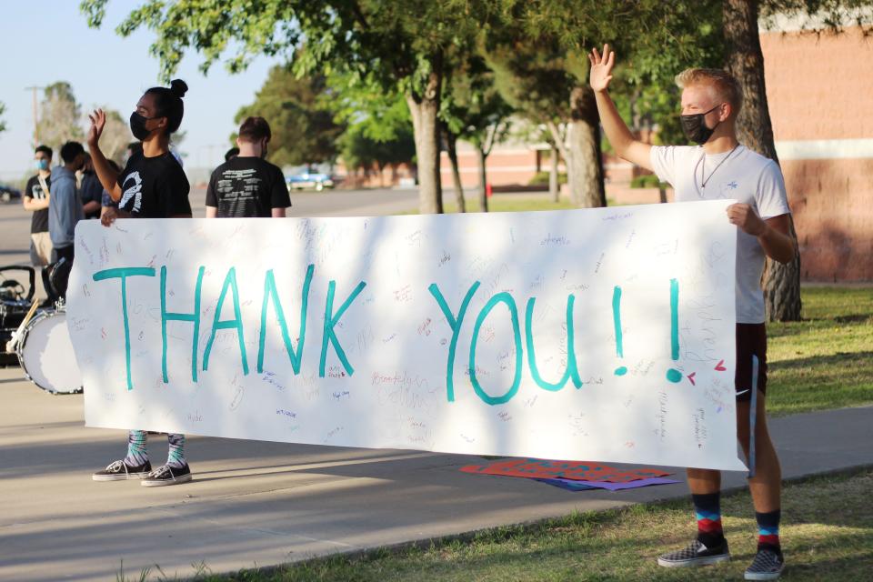 Students and parents gather at the Oñate High School staff parking lot and thank them for their service as teachers for the last day of Teacher Appreciation Week on Friday, May 7, 2021. Two juniors, Andrew Parks, right, and Jonathan Torres, left, wave to teachers as they drive.