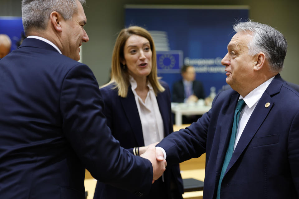 Hungary's Prime Minister Viktor Orban, right, shakes hands with Austria's Chancellor Karl Nehammer, left, next to European Parliament President Roberta Metsola during a round table meeting at an EU summit in Brussels, Thursday, Feb. 1, 2024. European Union leaders meet in Brussels for a one day summit to discuss the revision of the Multiannual Financial Framework 2021-2027, including support for Ukraine. (AP Photo/Geert Vanden Wijngaert)