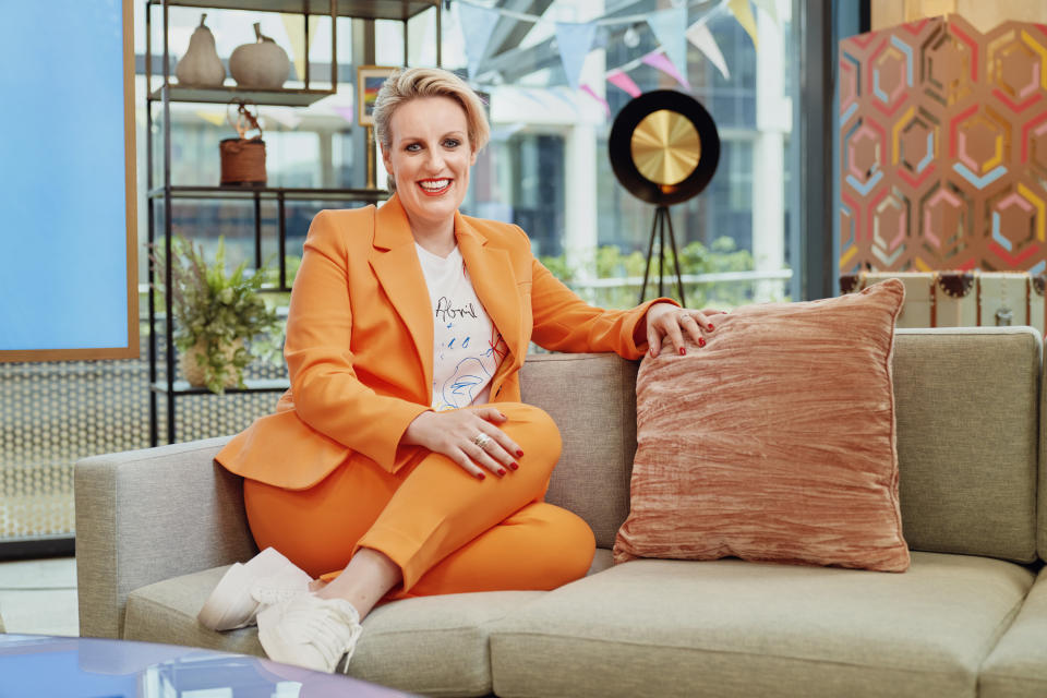 Steph McGovern wears orange while on the sofa for Steph's Packed Lunch