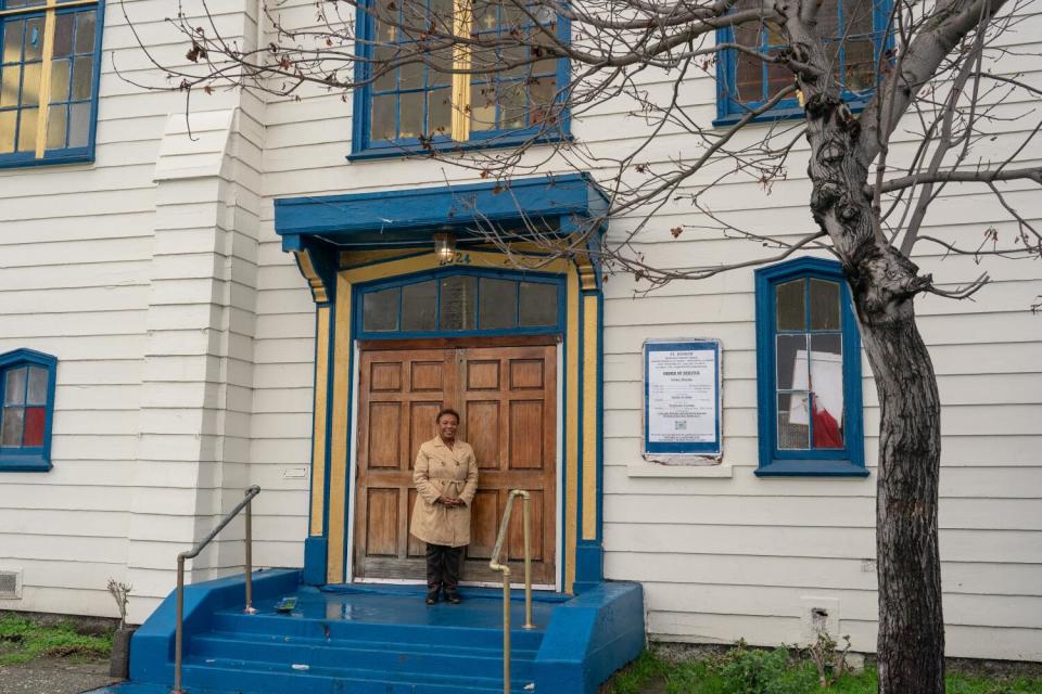 A woman stands in front of the church.