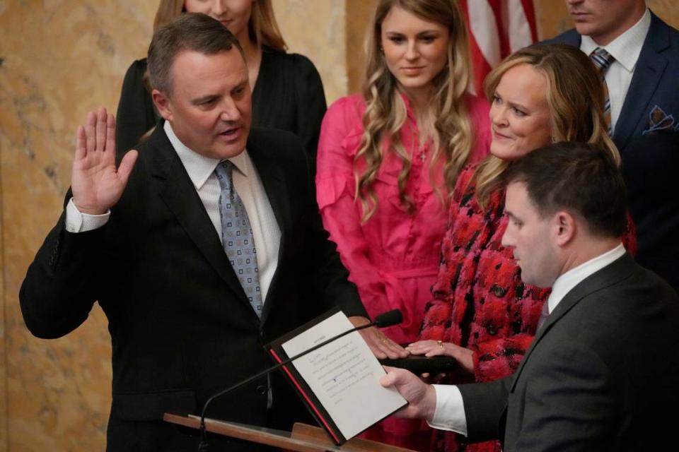 Jolynn McLellan White, second from right, holds the Bible as her husband, Rep. Jason White, R-West, left, recites the oath of office as Speaker for the Mississippi House of Representatives earlier this year.