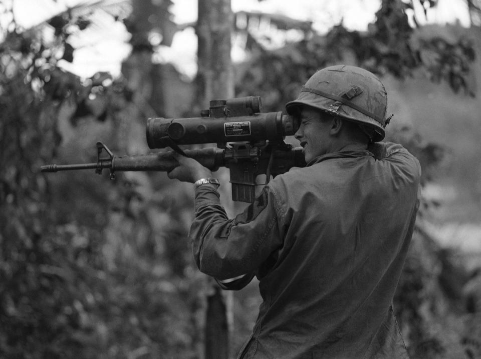 A cavalry soldier looks through a "starlight scope" that is attached to an M16 rifle in Vietnam in 1967.