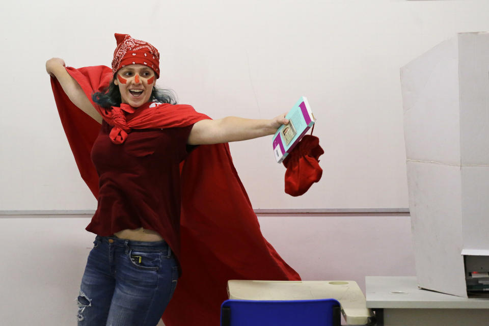 A woman, donning the Workers' Party official colror celebrates after voting in the presidential runoff election in Sao Paulo, Brazil, Sunday, Oct. 28, 2018. Brazilian voters decide who will next lead the world's fifth-largest country, the left-leaning Fernando Haddad of the Workers' Party, or far-right rival Jair Bolsonaro of the Social Liberal Party. (AP Photo/Nelson Antoine)