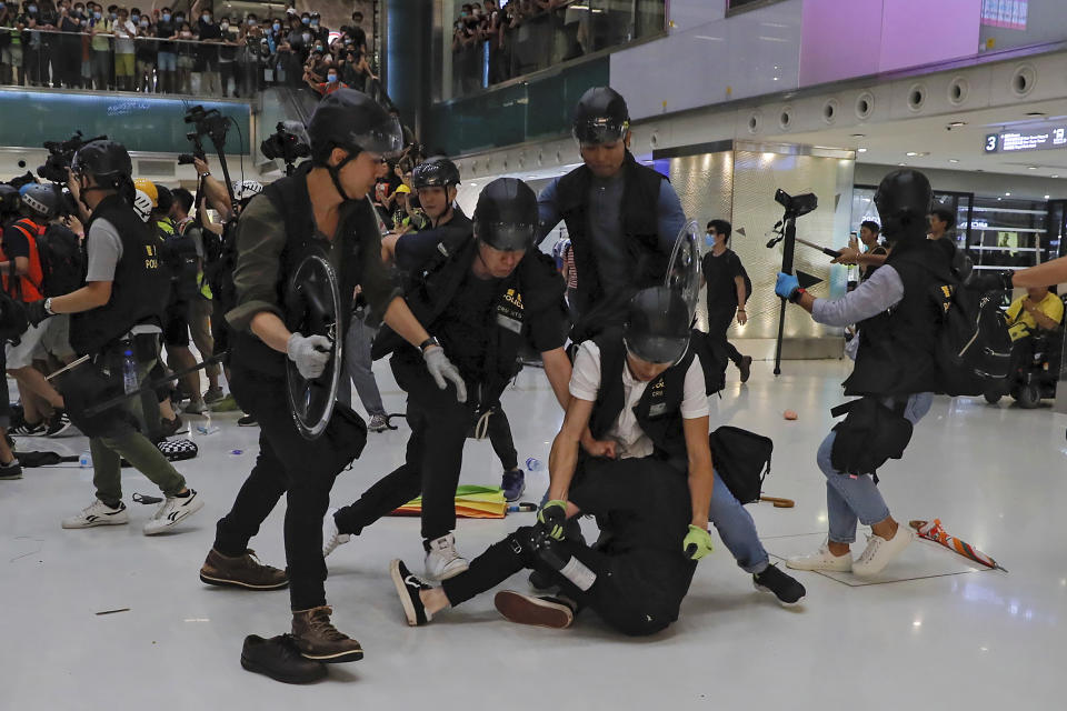 A protester is tackled by policemen after a scuffle inside a shopping mall in Sha Tin District in Hong Kong, Sunday, July 14, 2019. Police in Hong Kong have fought with protesters as they broke up a demonstration by thousands of people demanding the resignation of the Chinese territory's chief executive and an investigation into complains of police violence. (AP Photo/Kin Cheung)