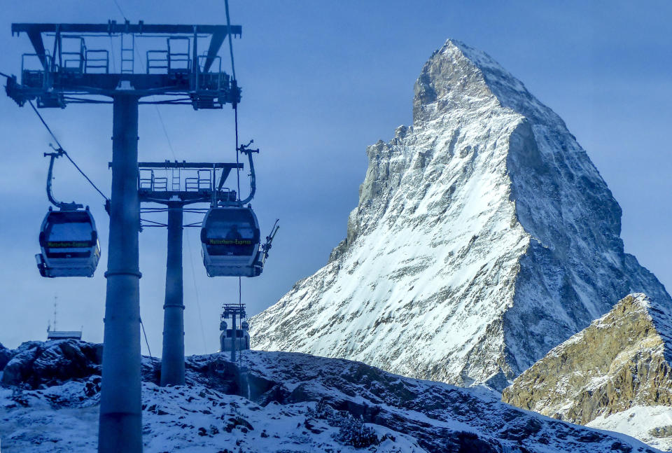 Gondolas go up next to the Matterhorn in Zermatt, Switzerland, Thursday, Dec.3, 2020. Zermatt is home to one of the Swiss ski stations that has become an epicenter of discord among Alpine neighbors. EU member states Austria, France, Germany and Italy are shutting or severely restricting access to the slopes this holiday season amid COVID-19 concerns, Switzerland is not. (AP Photo/Jamey Keaten)