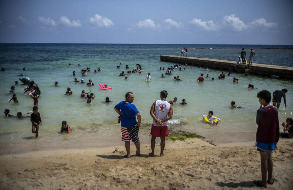 La gente disfruta el día en la Playa del Salado en Caimito, provincia de Artemisa, Cuba, el miércoles 15 de julio de 2020. Por las menores restricciones gubernamentales y la ola de calor que azota a la isla, miles de cubanos están abarrotando las playas. Después de una cuarentena de más de tres meses, la tasa de infección por COVID-19 sigue siendo extremadamente baja. (AP Foto/Ramón Espinosa)