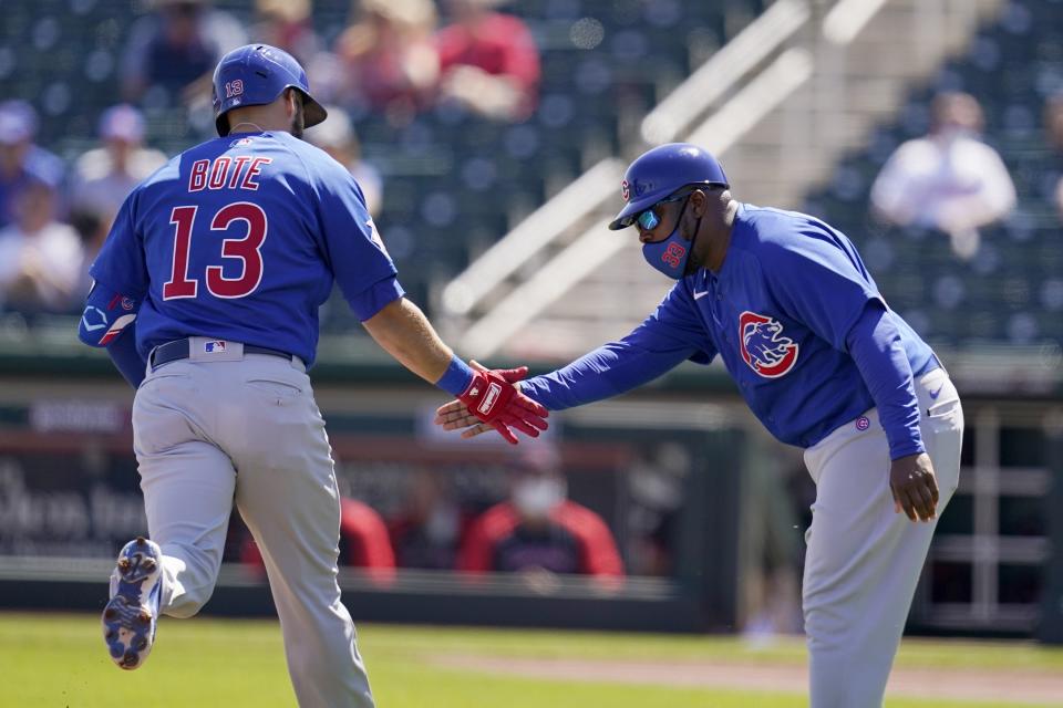 Chicago Cubs' David Bote (13) celebrates his home run against the Cleveland Indians with Cubs third base coach Willie Harris during the first inning of a spring training baseball game Thursday, March 18, 2021, in Goodyear, Ariz. (AP Photo/Ross D. Franklin)