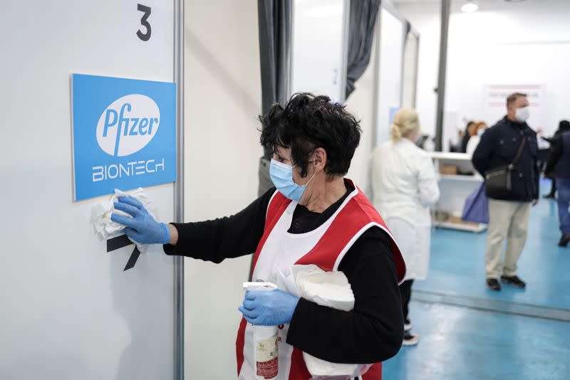 A healthcare worker disinfects a booth where people receive doses of Pfizer's coronavirus disease (COVID-19) vaccine at Belgrade Fair vaccination center in Belgrade