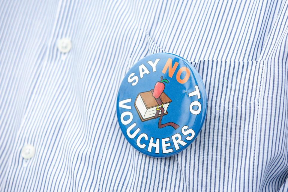 Andres Rosas, president of the local chapter of Steelworkers Organization of Active Retirees, wears a pin and protests with the Corpus Christi American Federation of Teachers against school vouchers and for Proposition 9 on Monday, Oct. 9, 2023, in Corpus Christi, Texas.
