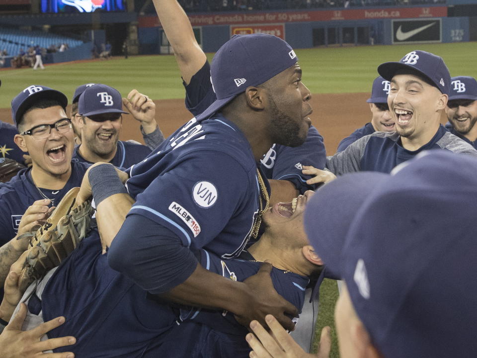 Tampa Bay Rays players celebrate on the field after they defeated the Toronto Blue Jays and clinched an MLB American League wild-card berth in Toronto, Friday, Sept. 27, 2019. (Fred Thornhill/The Canadian Press via AP)