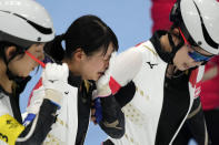 Nana Takagi of Team Japan is comforted by teammates after falling during the speedskating women's team pursuit finals at the 2022 Winter Olympics, Tuesday, Feb. 15, 2022, in Beijing. (AP Photo/Ashley Landis)