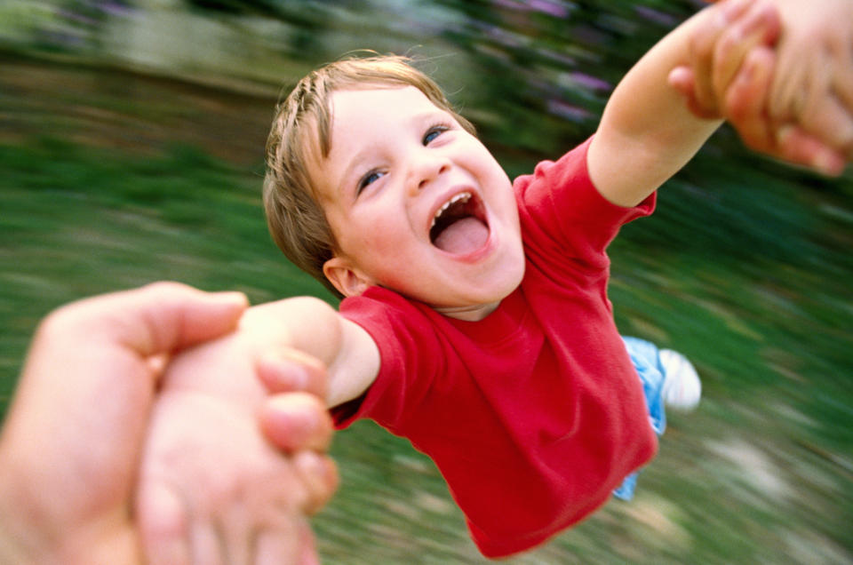 Boy (3-5) being swung by arms