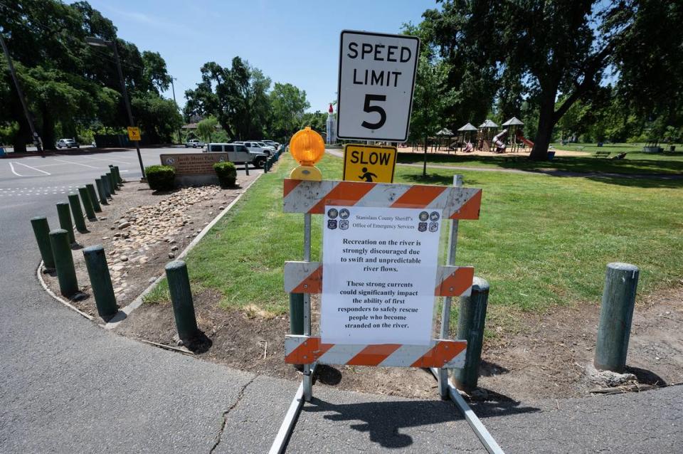 A sign from Stanislaus County Sheriff’s Office of Emergency Services warns visitors of unpredictable river flows on the Stanislaus River at Jacob Myers Park in Riverbank, Calif., Thursday, May 11, 2023.