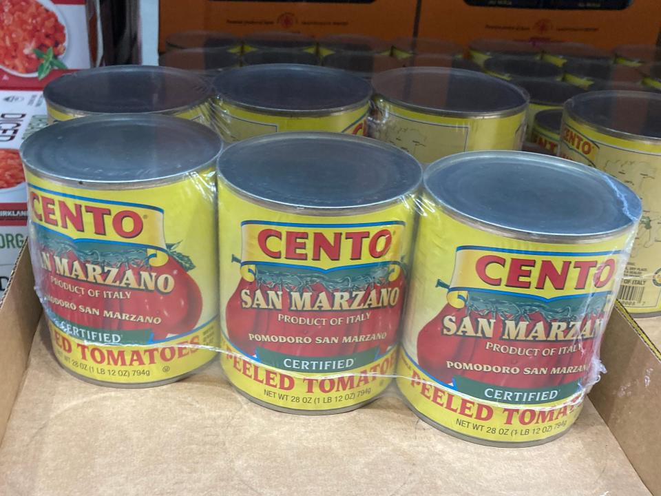 Three-packs of Cento canned tomatoes in yellow cans at Costco