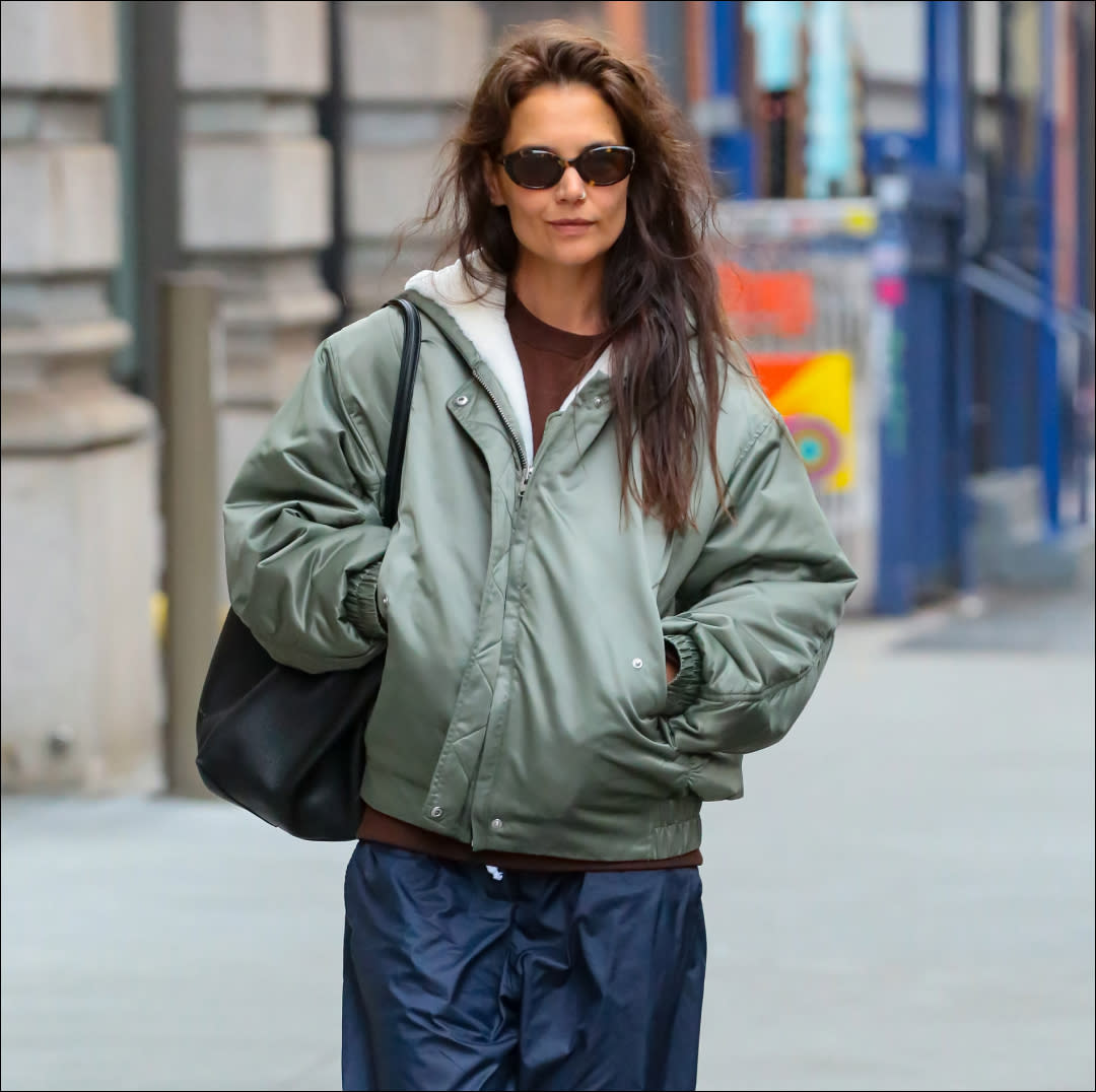  Katie Holmes outfit repeat in shearling bomber jacket, nylon pants, and adias sambas. 