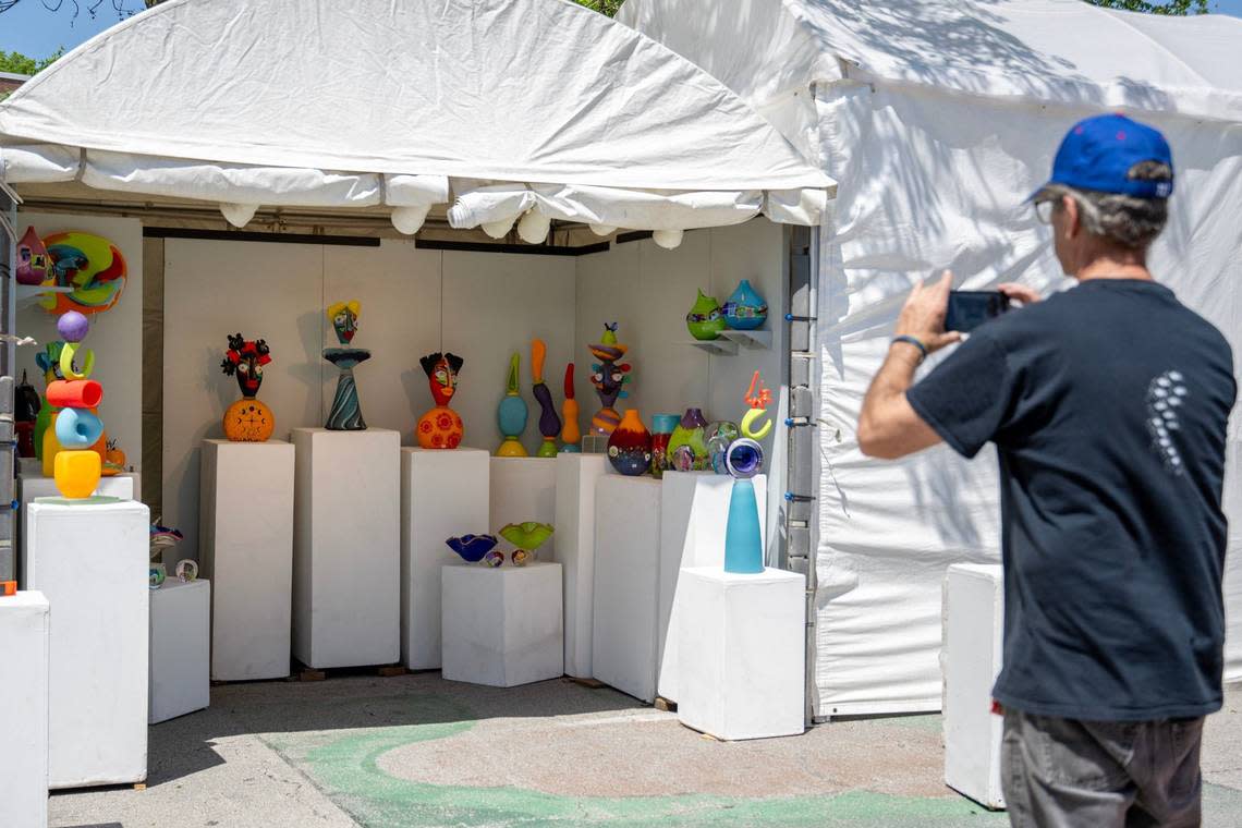 James Wilbat, from Deerfield, Illinois, snaps a photo on his phone after completing the setup of his booth for the Brookside Art Annual.