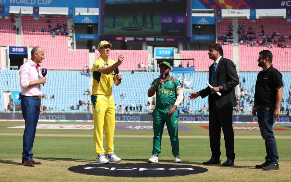 Pat Cummins of Australia flips the coin as Temba Bavuma of South Africa looks on ahead of the ICC Men's Cricket World Cup India 2023 between Australia and South Africa at BRSABVE Cricket Stadium on October 12, 2023 in Lucknow, India.