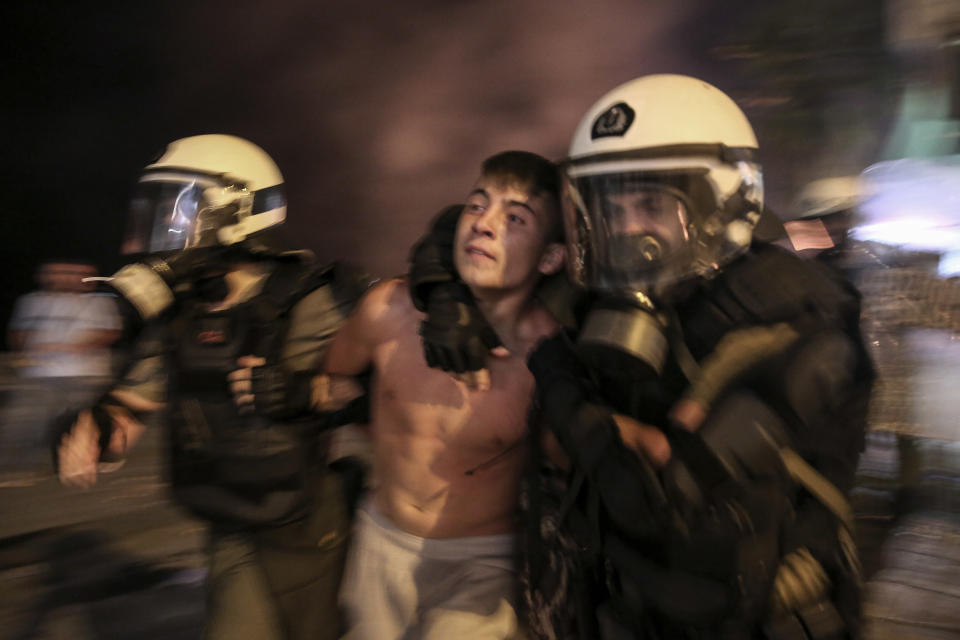 A protester is detained by riot policemen during clashes at the northern Greek city of Thessaloniki, Saturday, Sept. 8, 2018. Police in northern Greece have clashed with protesters outside an international trade fair where prime minister Tsipras made a keynote speech. (AP Photo/Dimitris Tosidis)