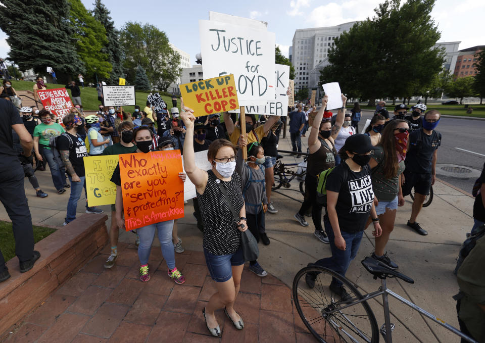 Participants carry placards during a protest outside the State Capitol over the death of George Floyd, a handcuffed black man in police custody in Minneapolis, Thursday, May 28, 2020, in Denver. Close to 1,000 protesters walked from the Capitol down the 16th Street pedestrian mall during the protest. (AP Photo/David Zalubowski)