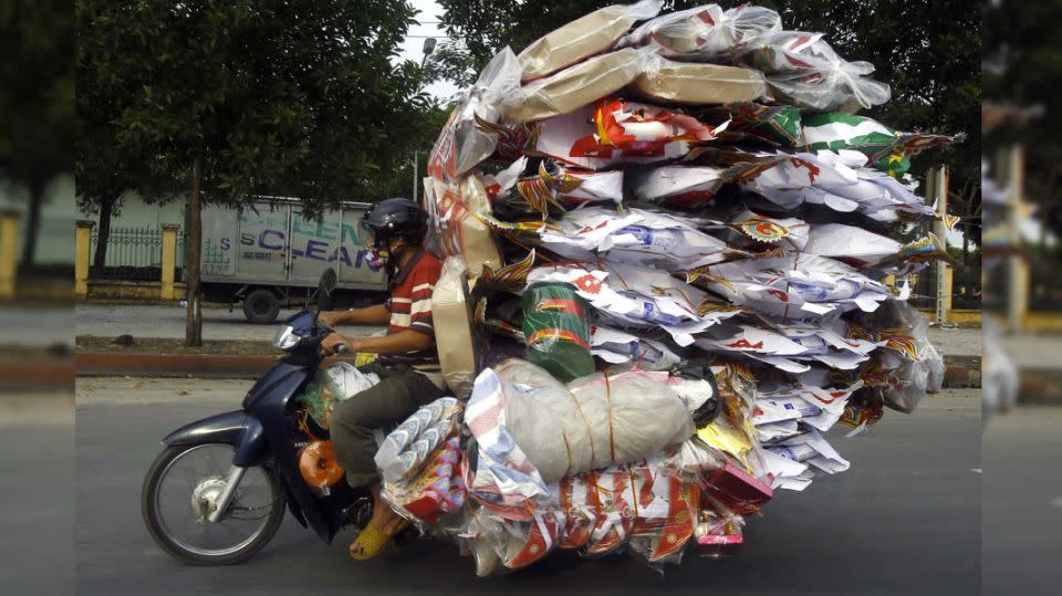 A scooter driver packs his vehicle to the brim with miscellaneous items. Photo: Reuters