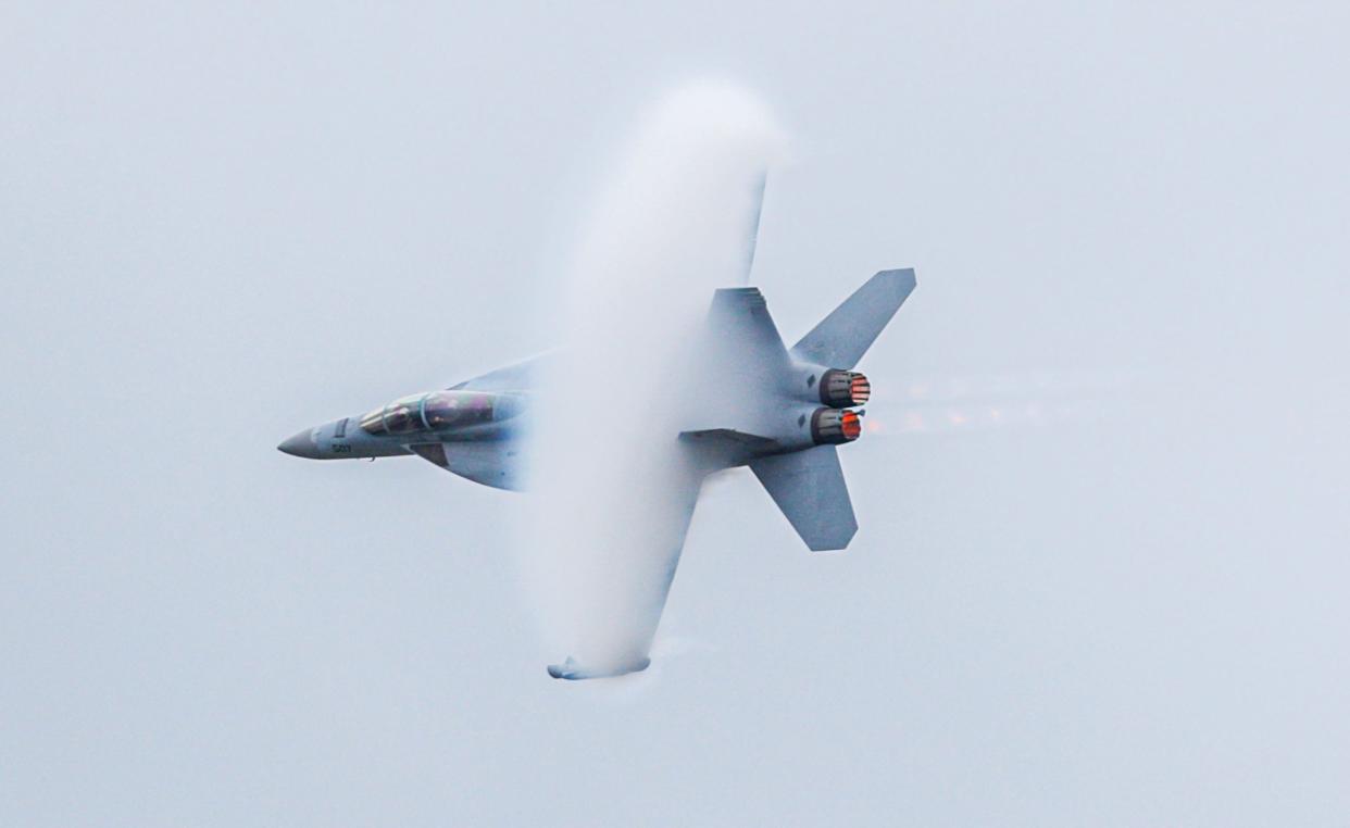 A vapor cone surrounds a Navy EA-18 Growler joins practices over Louisvllie.  Planes flew over Louisville and Southern Indiana on Friday morning, Friday, April 21, 2023, during practice for Thunder Over Louisville Air Show.