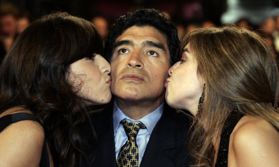 ARCHIVO - En esta foto del 20 de mayo de 2008, Diego Maradona recibe besos de sus hijas Giannina (izquierda) y Dalma al acudir a la premier de "Maradona" en el Festival de Canes, en el sur de Francia. Maradona ha fallecido de un paro cardíaco, el miércoles 25 de noviembre de 2020, en Buenos Aires. Tenía 60 años. (AP Foto/Francois Mori, archivo)