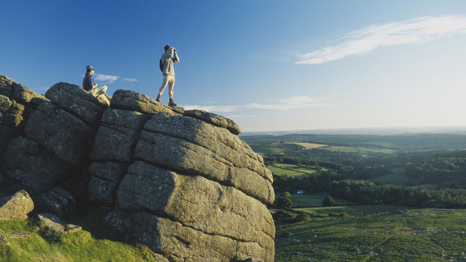 how do binoculars work: hikers on a rock using bins