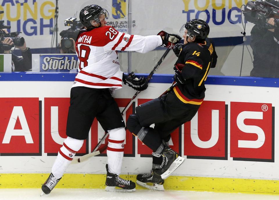 Canada's Anthony Mantha (L) checks Germany's Jonas Noske during the first period of their IIHF World Junior Championship ice hockey game in Malmo, Sweden, December 26, 2013. REUTERS/Alexander Demianchuk (SWEDEN - Tags: SPORT ICE HOCKEY)