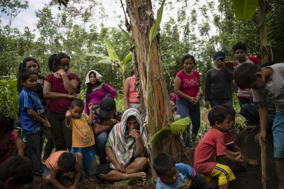 Relatives and neighbors attend the burial service for Jose Barbaran who is believed to have died from complications related to the new coronavirus, in Palestina, in Peru's Ucayali region, Wednesday, Sept. 30, 2020. As Peru grapples with one the world's worst virus outbreaks, another epidemic is starting to raise alarm: Dengue. (AP Photo/Rodrigo Abd)