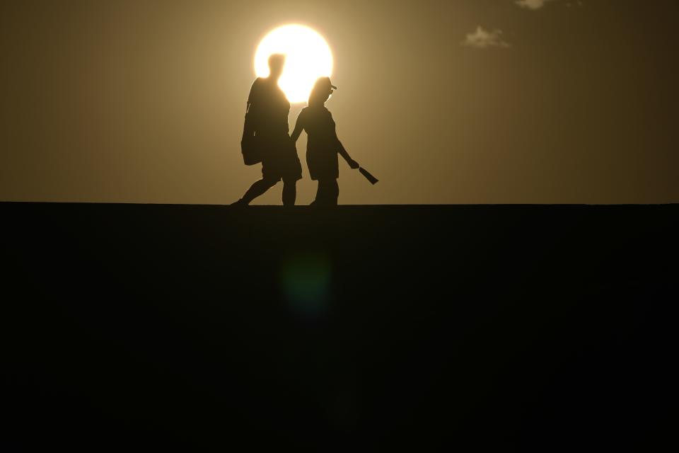 ARCHIVO - Una pareja camina por un sendero ante la puesta del Sol, el 16 de julio de 2023, en el Parque Nacional Death Valley, en California. (AP Foto/John Locher, archivo)