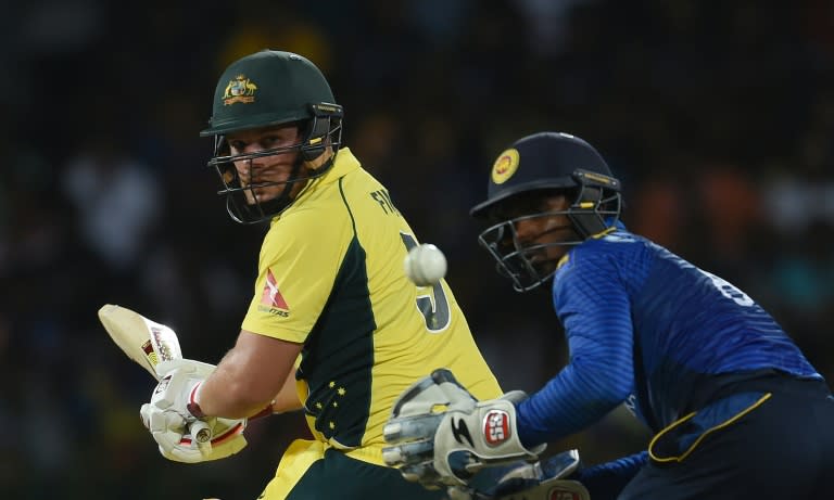 Australian cricketer Aaron Finch (L) plays a shot as Sri Lankan wicketkeeper Kusal Perera looks on in Colombo on August 21, 2016