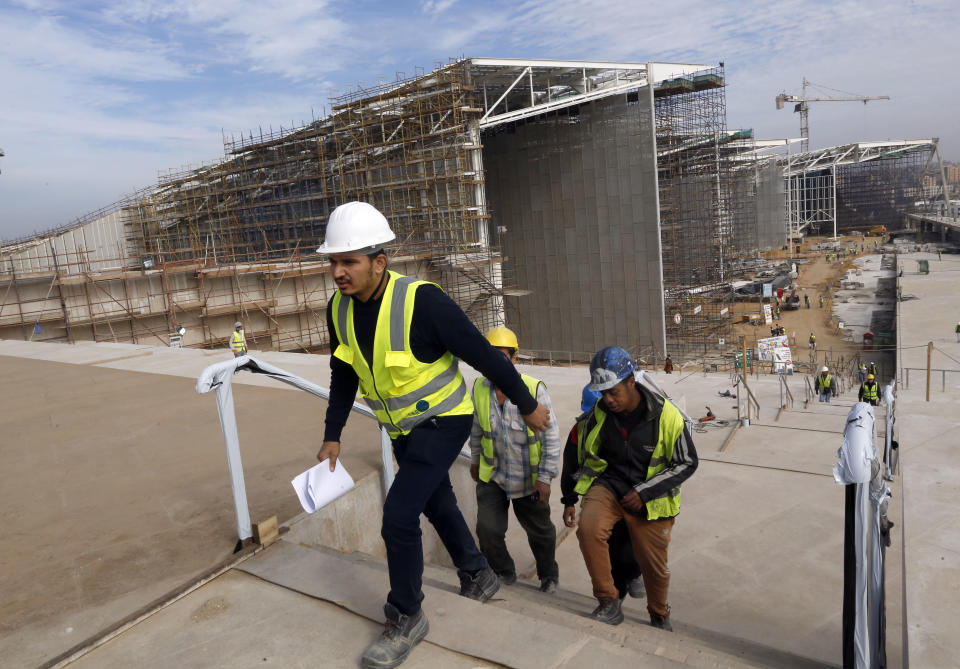 In this Sunday, Dec. 16, 2018 photo, workers go for a break at the Grand Egyptian Museum under construction in Giza, Egypt. Thousands of Egyptians are laboring in the shadow of the pyramids to erect a monument worthy of the pharaohs. The Grand Egyptian Museum has been under construction for well over a decade and is intended to show off Egypt’s ancient treasures while attracting tourists to help fund its future development.