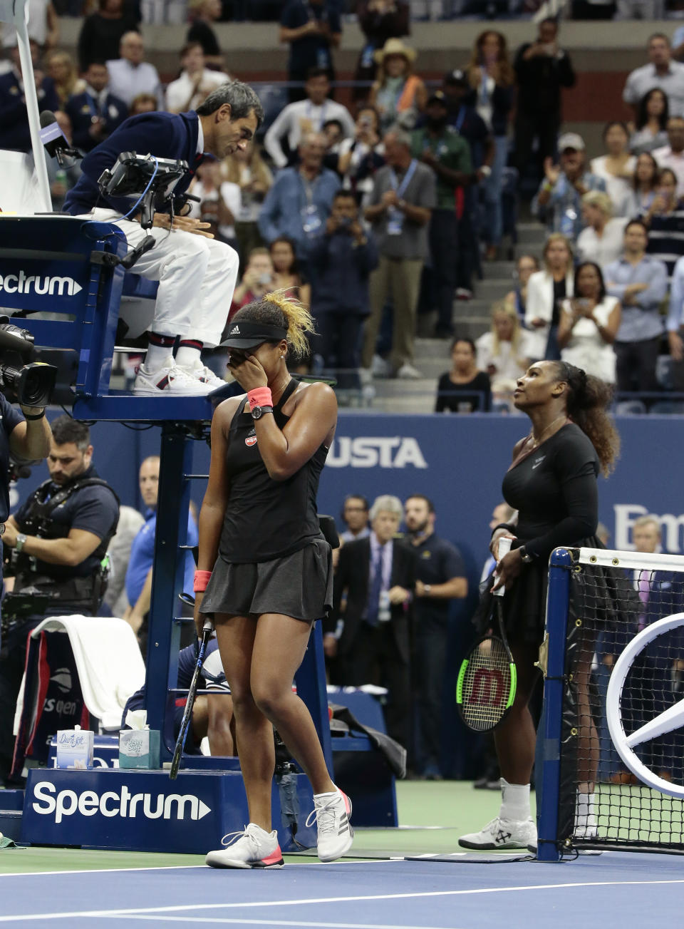 Naomi Osaka, of Japan, reacts as Serena Williams talks with chair umpire Carlos Ramos after Osaka defeated Williams in the women's final of the U.S. Open tennis tournament, Saturday, Sept. 8, 2018, in New York. (AP Photo/Andres Kudacki)