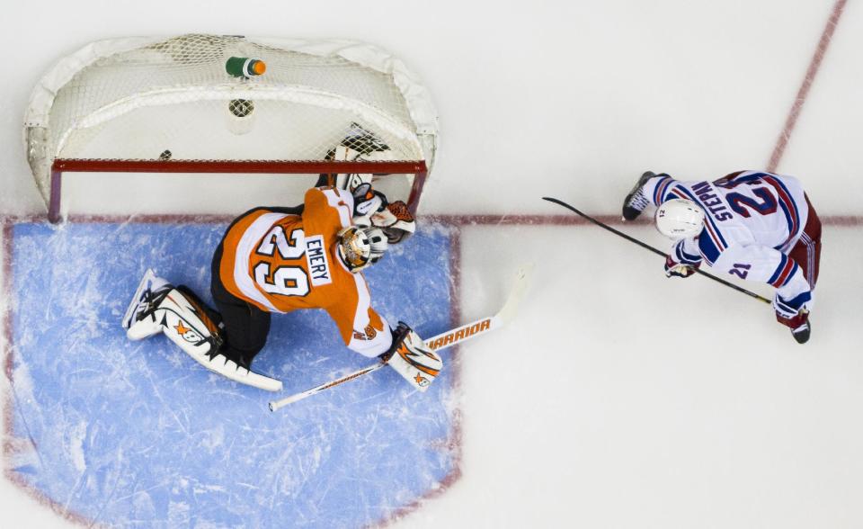 New York Rangers' Derek Stepan, right, gets the puck past Philadelphia Flyers' Ray Emery, left, for a goal during the first period in Game 3 of an NHL hockey first-round playoff series, Tuesday, April 22, 2014, in Philadelphia. (AP Photo/Chris Szagola)